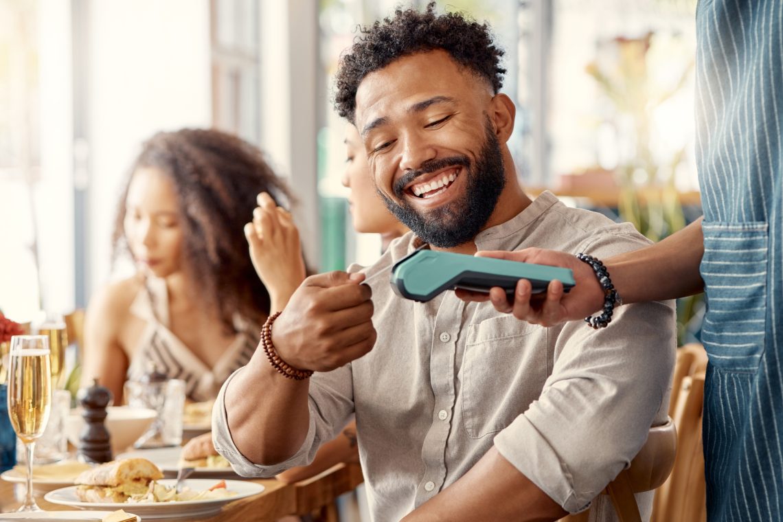 Man paying a waiter at a restaurant