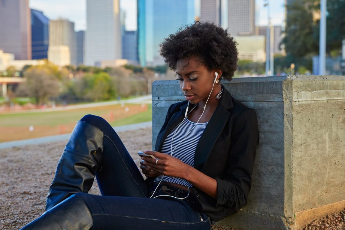 Woman with cellphone with Houston backdrop