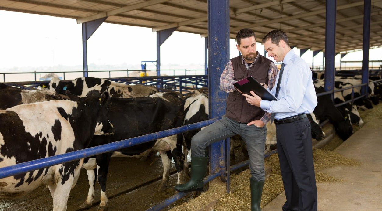 Banker speaking with farmer business concierge